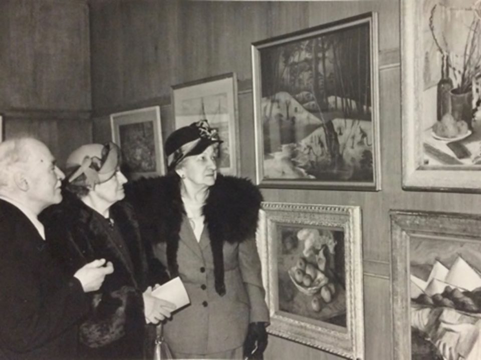 A pastel by Parnell Dempster adorns a wall at the Pastel Society in London in 1951, proudly talked about by Mrs. Rutter.
