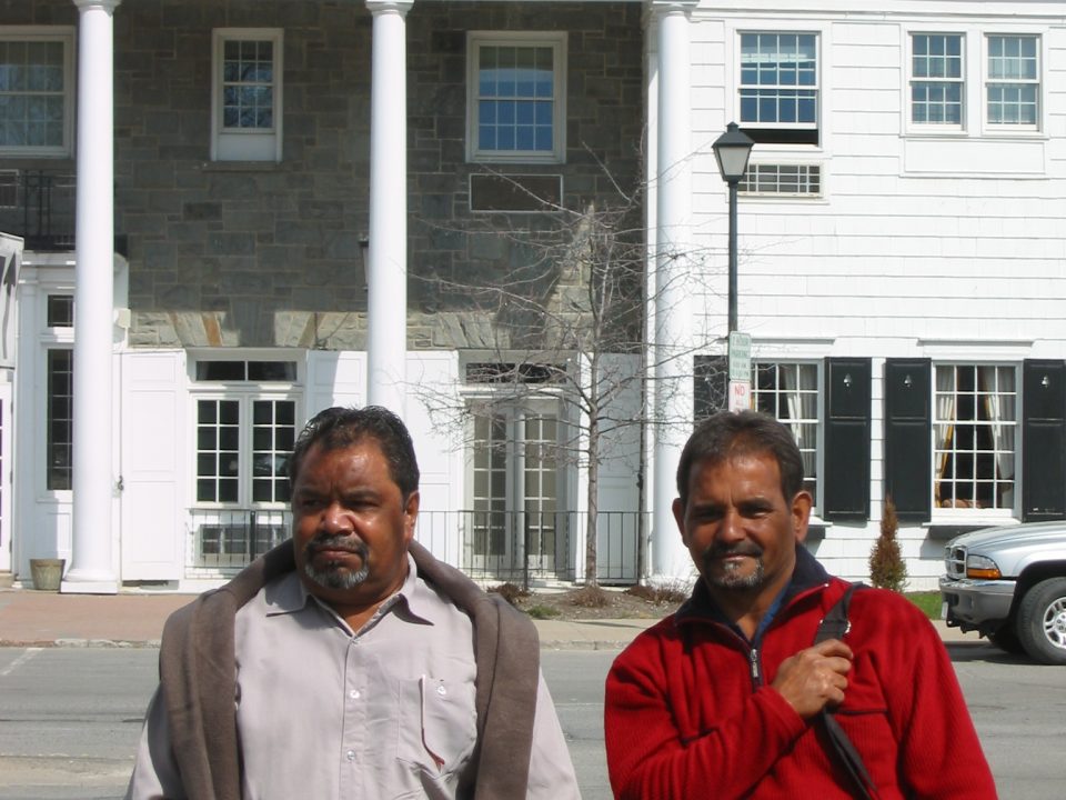 Ezzard Flowers and Athol Farmer (right) standing outside the Colgate University Guesthouse where they and John Stanton stayed when visiting Colgate University, Hamilton, New York State, 13th April 2005. Photograph taken by John Stanton. Berndt Museum of Anthropology, University of Western Australia.