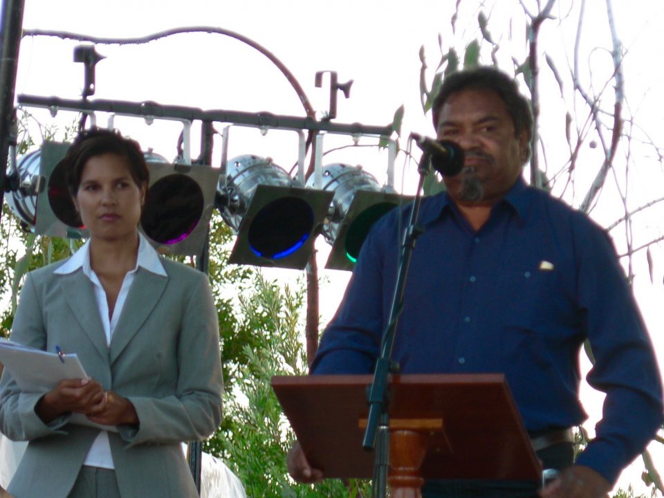 Ezzard Flowers speaking at the Official Opening of Koorah Coolingah exhibition, Katanning, with MC Norelle Jacobs in the background, 24th February 2006. Berndt Museum of Anthropology, The University of Western Australia.